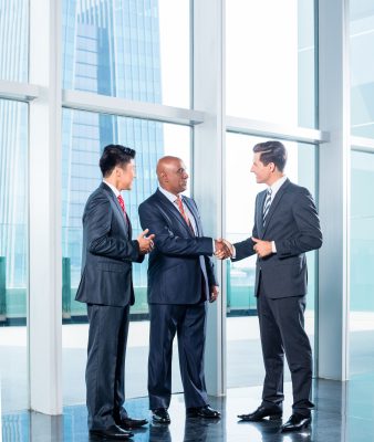 Business people shaking hands in a glass office